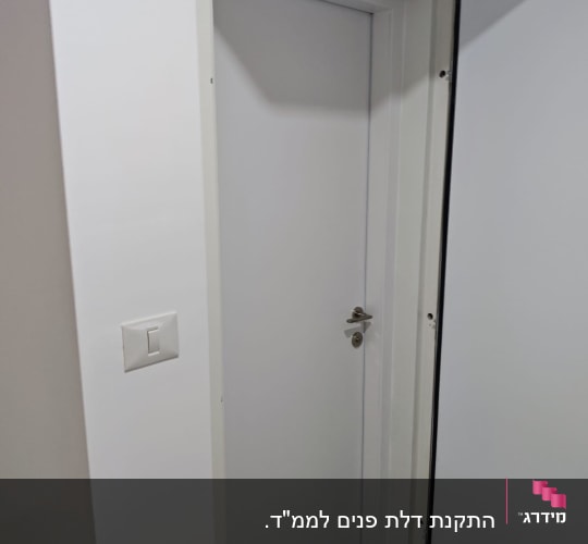 התקנת דלת פנים לבנה בפתח חדר ממ"ד